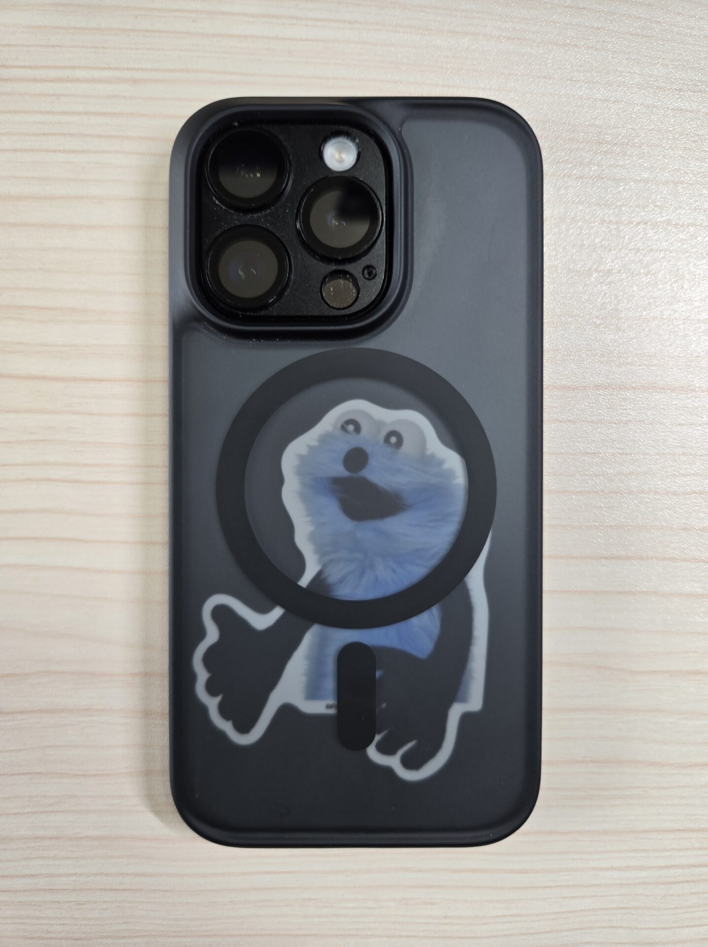 iPhoneの黒いスモークケースの裏側にうっすら見えるパペットスンスンのシール
